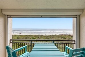 A balcony with a view of the beach.