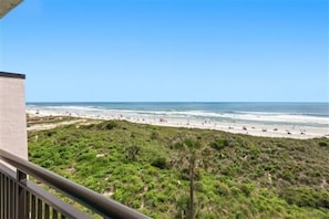 Blick auf den Strand mit einem Balkon mit Meer- und Strandblick.