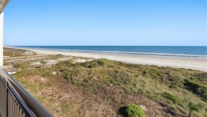 A coastal view from a balcony overlooking a beach with sparse vegetation and a clear sky. - Beacher's Oceanfront Balcony Suite with Onsite Front desk and staff (St. Augustine)