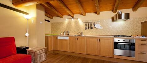 A kitchen with wooden cabinets, a stove, and a sink.