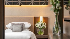 A hotel room with a bed, bedside table, and a vase with flowers. - Hyatt Regency Sofia (Sofia)