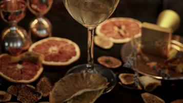 A glass of drink with a leaf garnish, surrounded by dried fruits and a decorative box.