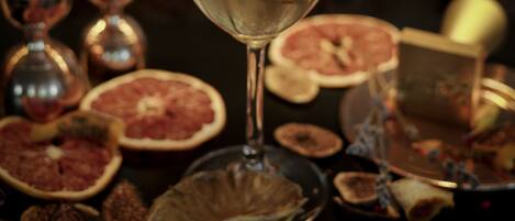 A glass of drink with a leaf garnish, surrounded by dried fruits and a decorative box.