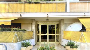 A building entrance with a glass door, a nameplate, and two potted plants. - Large and Quiet Studio with Balcony (Cannes)