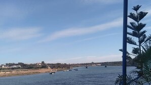 Um rio com barcos, uma ponte e um céu claro.
