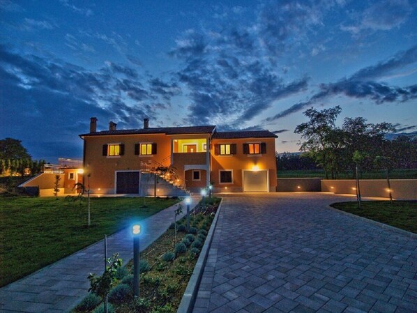 A two-story house with a paved driveway and a well-lit entrance. - NEW!! Spacious and luxurious apartment with private 50m2 pool! (Pazin)