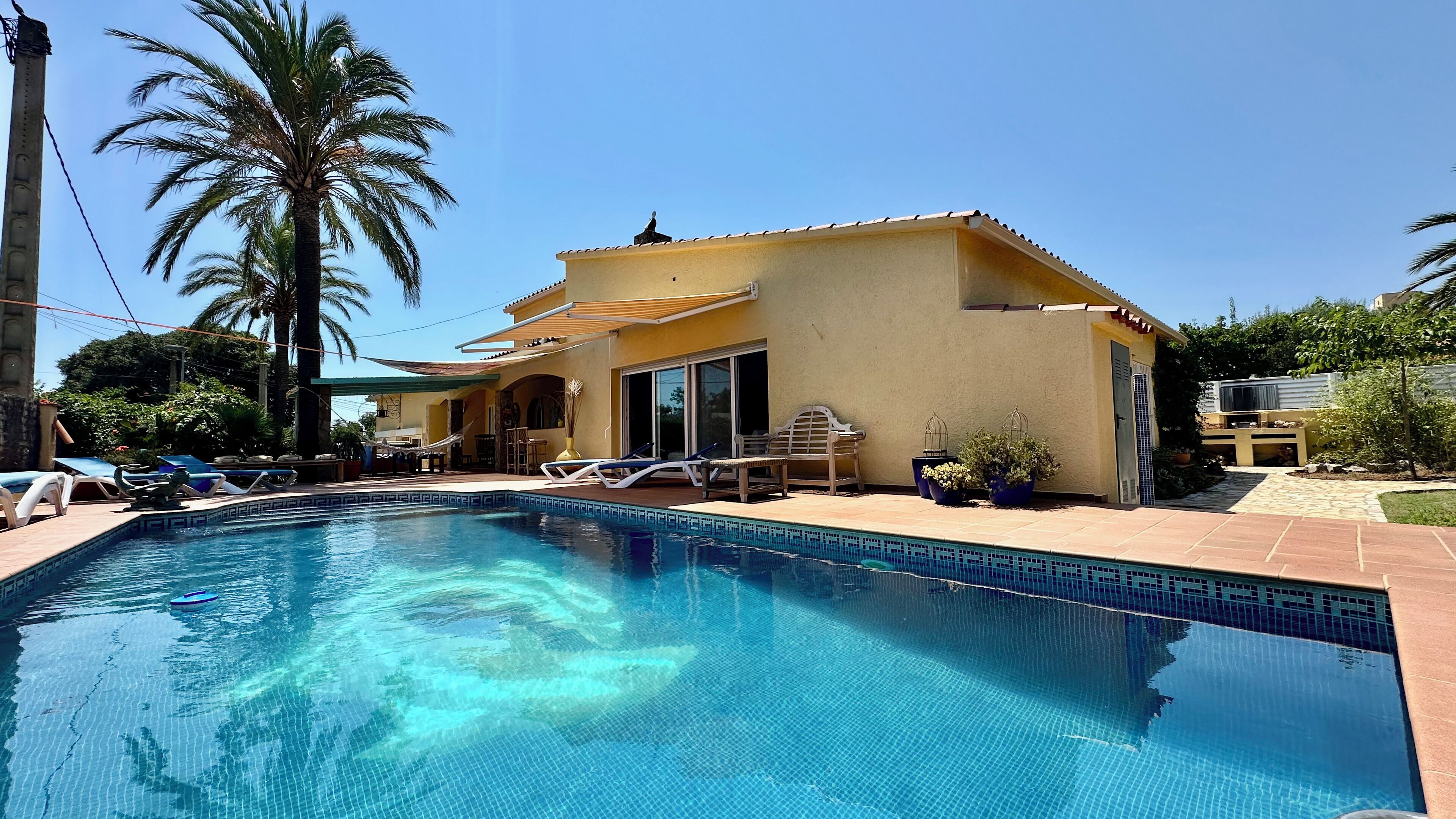 A swimming pool with lounge chairs and a patio area.