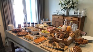 Un buffet de petit-déjeuner proposant une variété d’aliments et une table en bois.