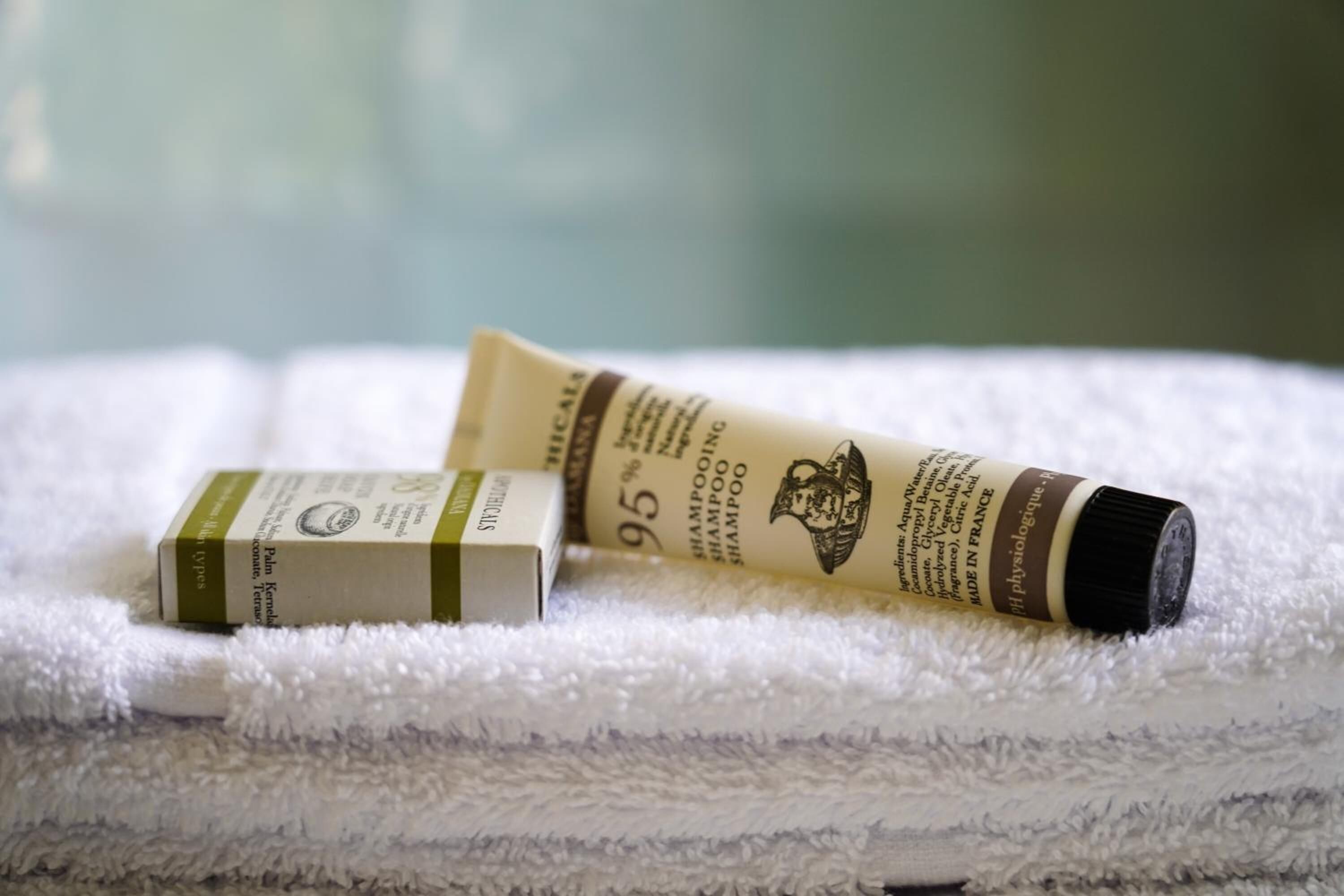 A tube of shampoo and a box on a white towel.