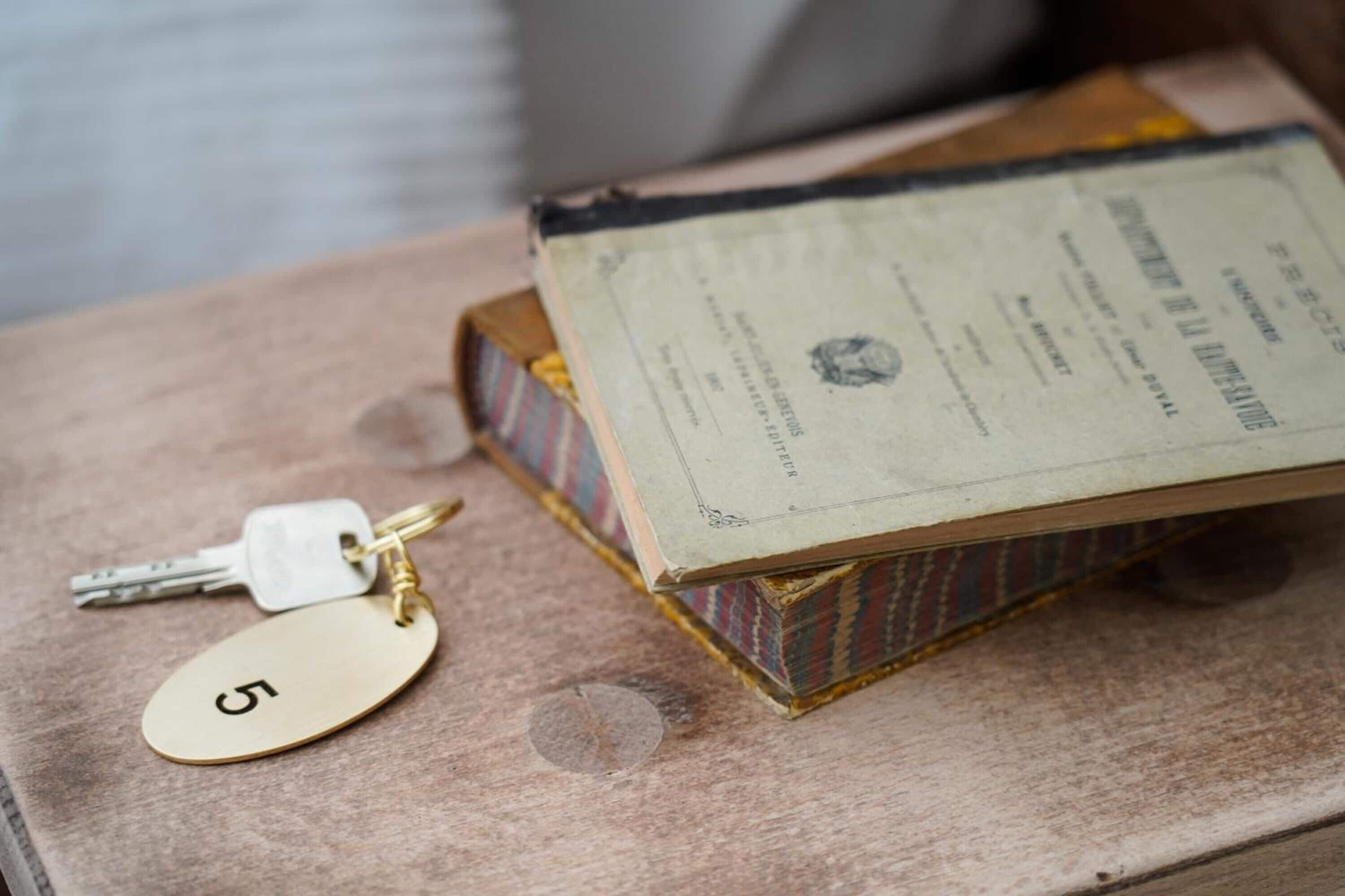 A set of keys with a keychain labeled '5' and a book with a visible page.