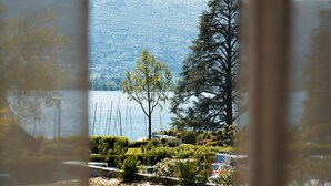 Un lac avec des bateaux, un arbre et une montagne en arrière-plan.