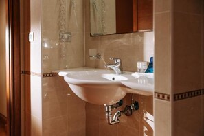 A bathroom with a white sink, chrome faucet, and a mirror above it. - Valtur Otium Resort (Villapiana)