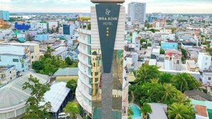Um hotel de vários andares com uma placa em destaque que diz 'HORA EINH HOTEL'.