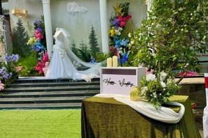 A wedding setup with a bride on steps, floral arrangements, and a sign reading 'Anna Wedding'. - Hoa Binh 1 Hotel (Long Xuyen)