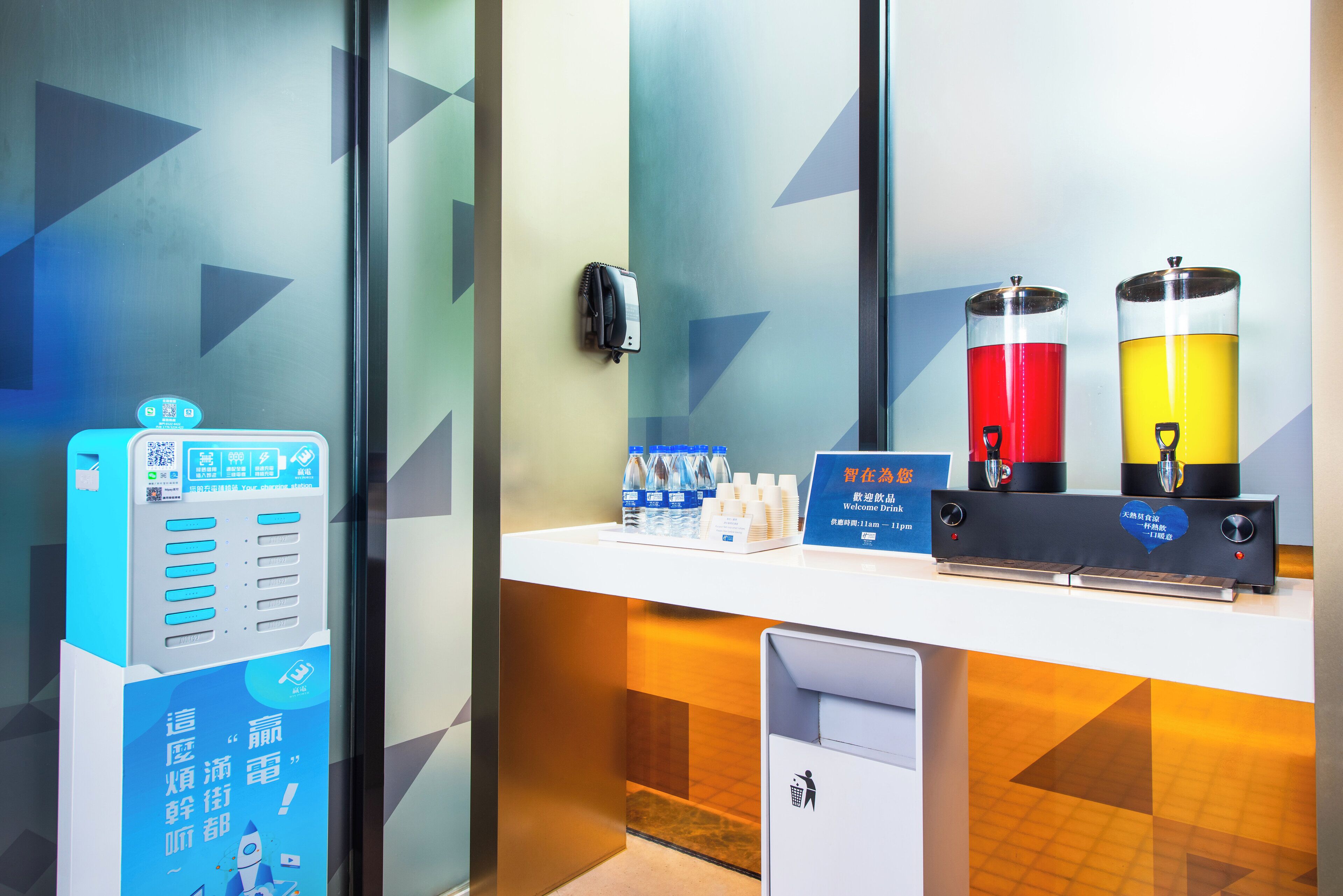 A reception area with a self-service kiosk, a water dispenser, and a sign welcoming guests.