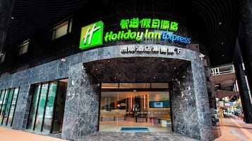 Welcome to Holiday Inn Express, featuring a modern entrance with glass doors and a convenient blue carpet leading up to the entrance.