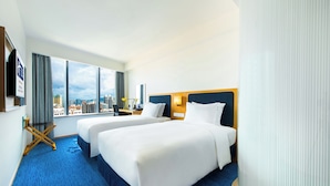 A hotel room with two beds, a city view, and a blue carpet. - Holiday Inn Express Macau City Centre (Macau)