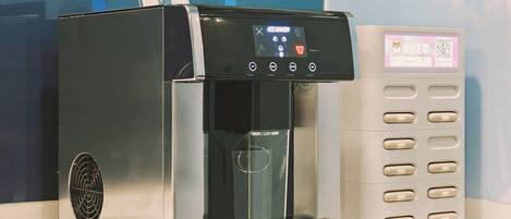 A modern ice dispenser with a digital display, a glass container, and a card reader.