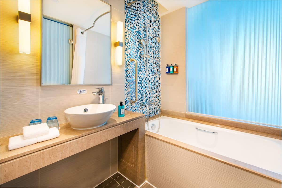 rainfall showerhead, hair dryer, slippers, towels