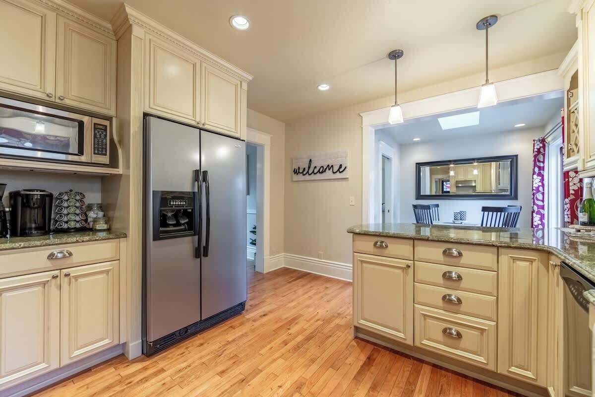 A kitchen with light-colored cabinets, a stainless steel refrigerator, a microwave, and a coffee maker.