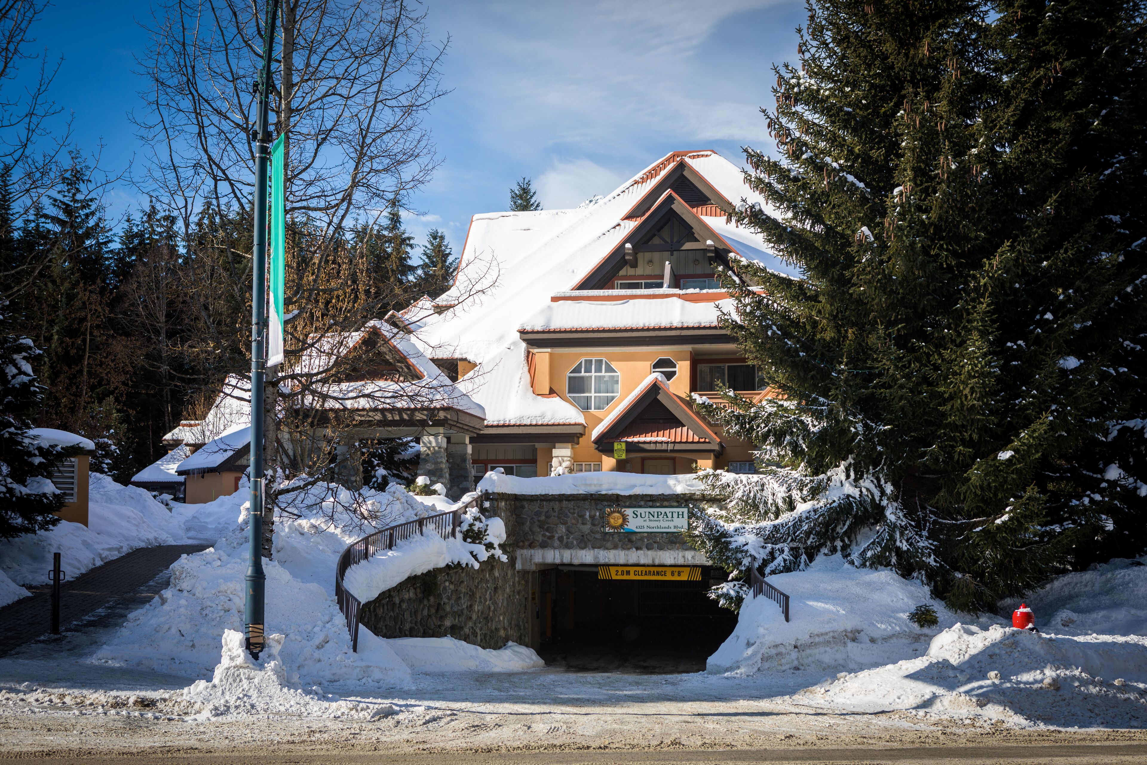 Een lodge met een gevel van steen, een ruime ingang en een bordje waarop staat dat het een Sunpath resort is.
