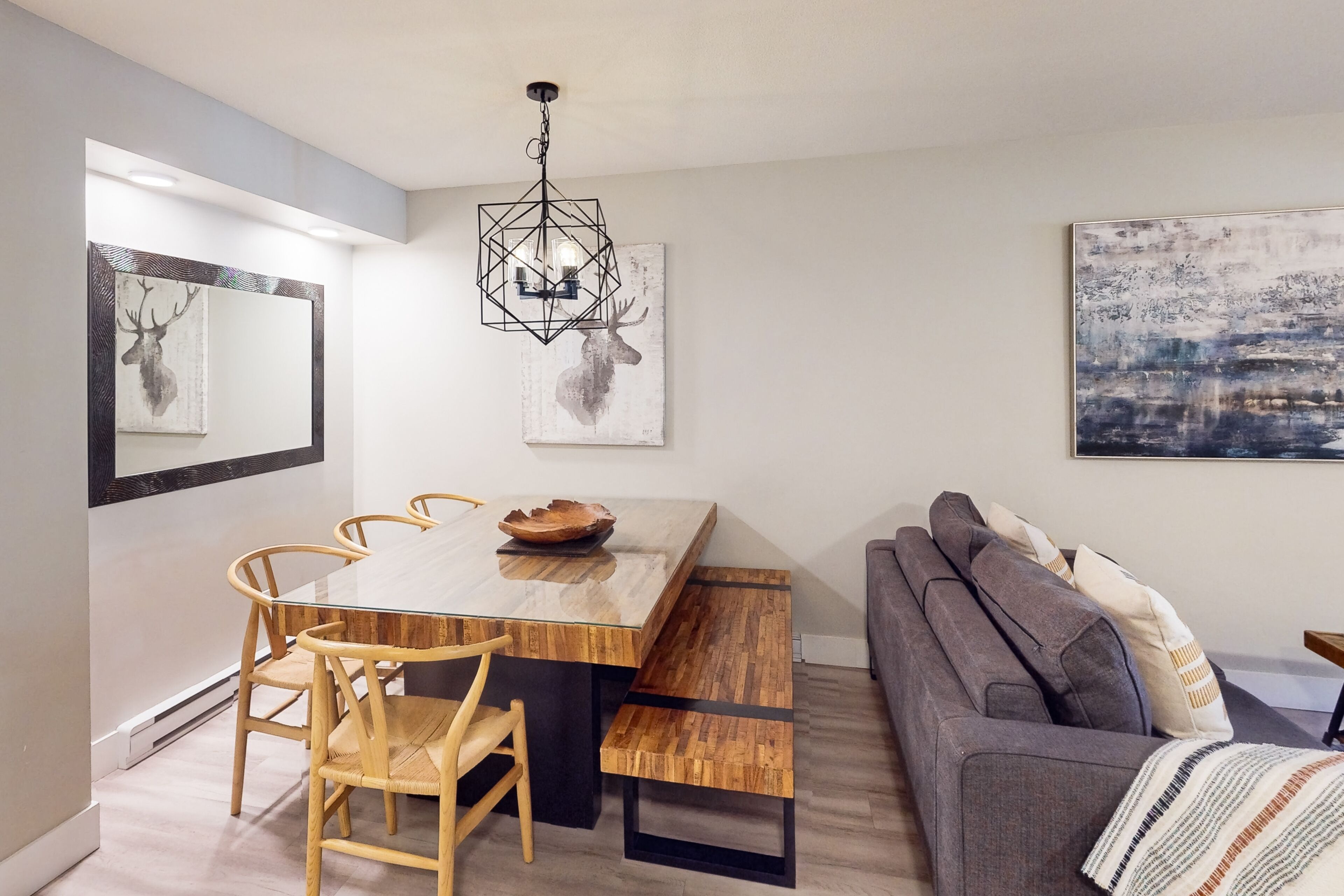 A modern dining area with a wooden table, chairs, and a bench.