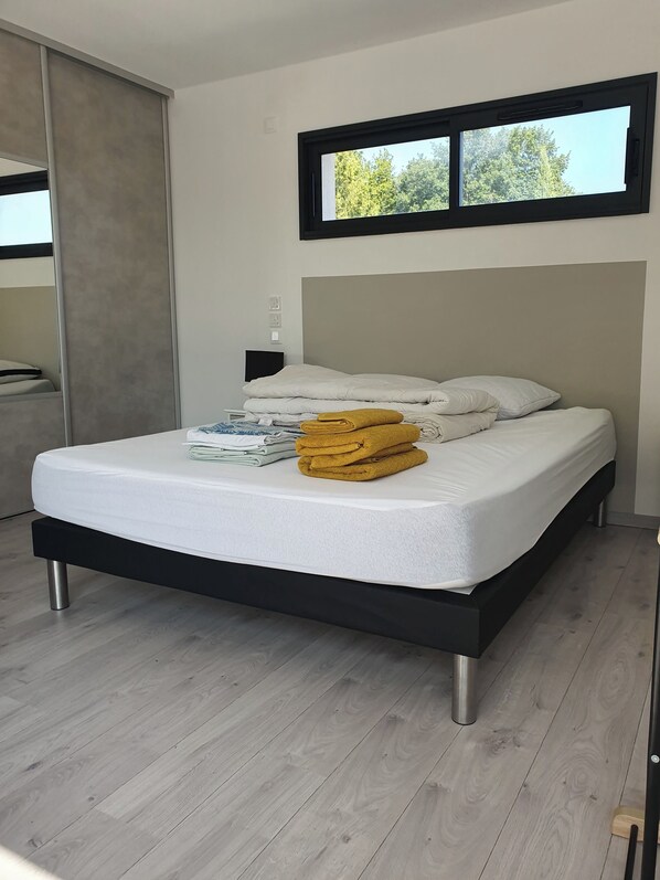 A modern bedroom with a bed, a window, and a wooden floor. - Contemporary villa with heated pool (Saint-Sulpice-de-Royan)