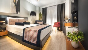 A modern hotel room with a large bed, bedside tables, a desk, and a potted plant. - Ooda Rooms Kadıköy (Istanbul)