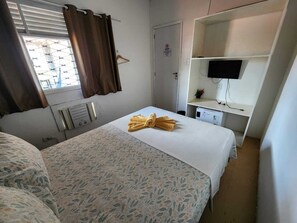 A hotel room with a bed, a desk, a TV, and a window with curtains. - Casa do Meio Pousada (Recife)