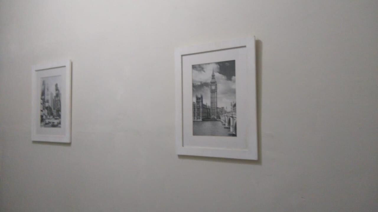 Dos fotografías blanco y negro enmarcadas sobre una pared lisa.