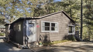 Une petite cabane à un seul étage, avec une porte d’entrée, une fenêtre et une pancarte indiquant qu’il s’agit d’un chalet.