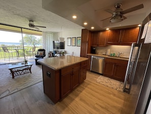 A modern kitchen with wooden cabinets, a stainless steel refrigerator, and a built-in dishwasher.
