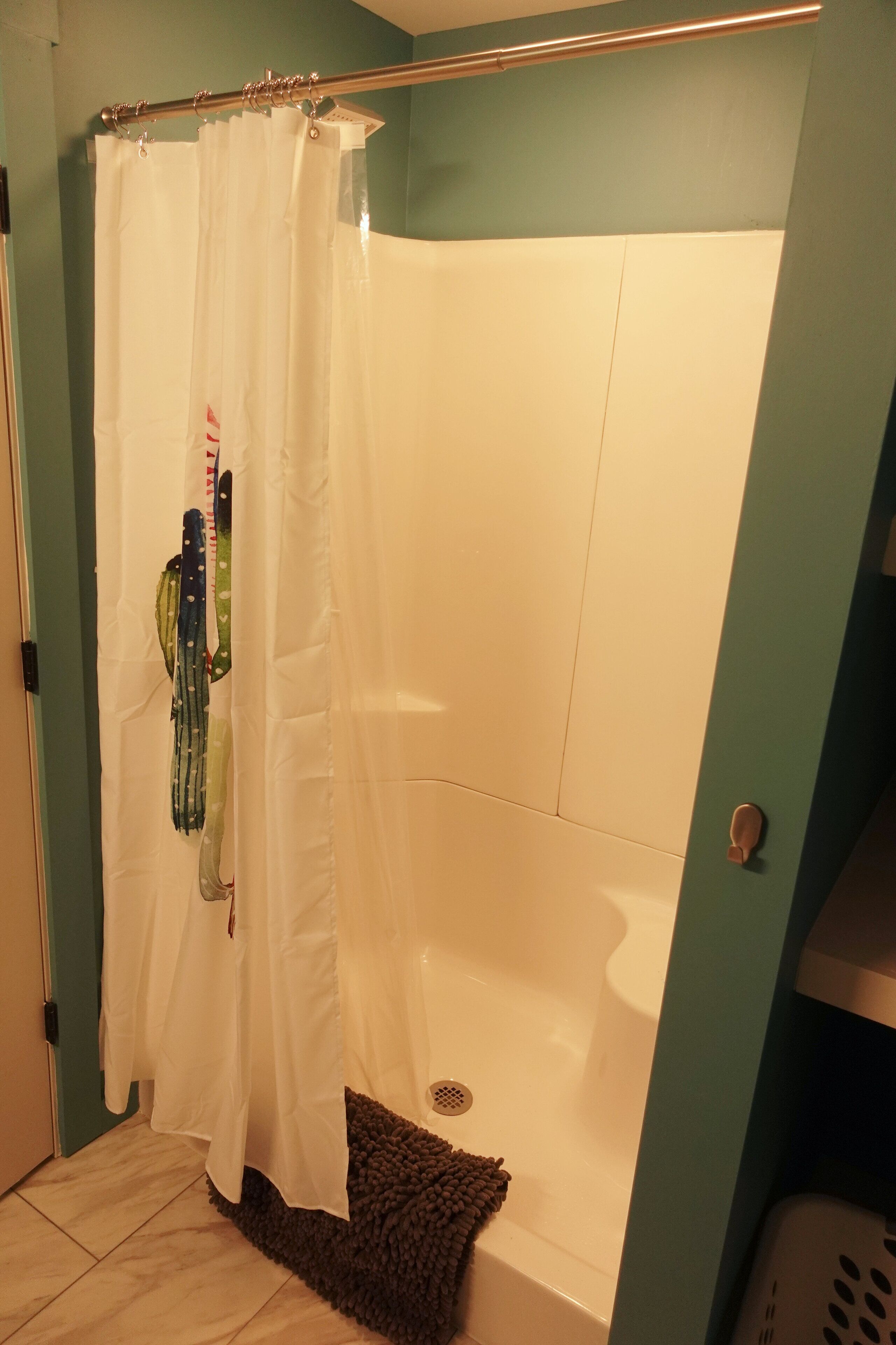 Ein Badezimmer mit Duschvorhang, Badewanne und Handtuchhalter mit Handtüchern.