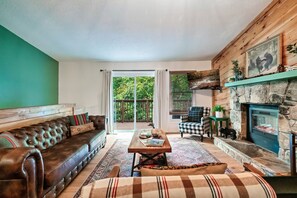 Relax in this inviting living room with a leather sofa, wooden coffee table, and stone fireplace.