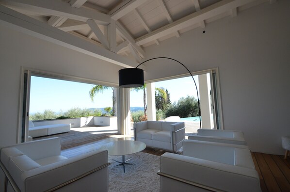 A modern living room with white furniture, large windows, and a view of the outdoors. - DREAMING PLACE FOR HOLLYDAY (Le Tignet)