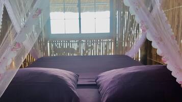 Una habitación con cama, ventana y pared de bambú.
