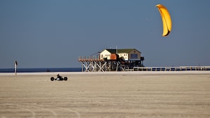 A beach house on stilts with a clear view of the ocean.