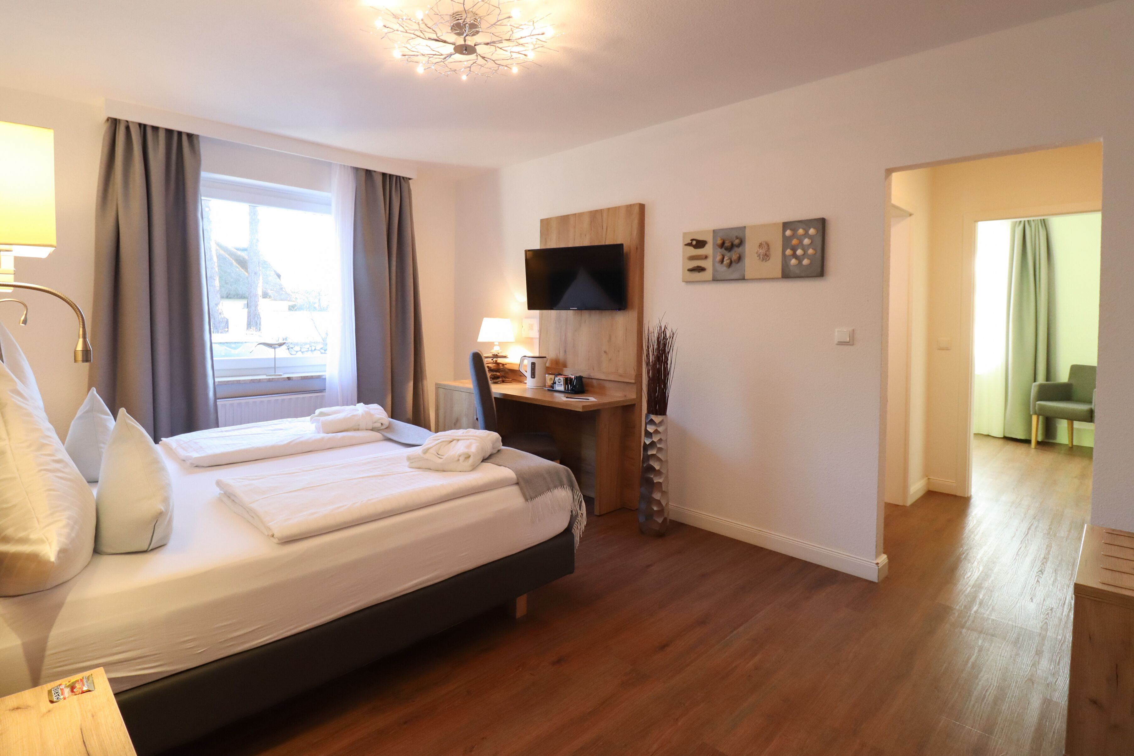 Une chambre d’hôtel moderne dotée d’un grand lit, d’un bureau avec un téléviseur à écran plat et offrant une vue sur l’extérieur.