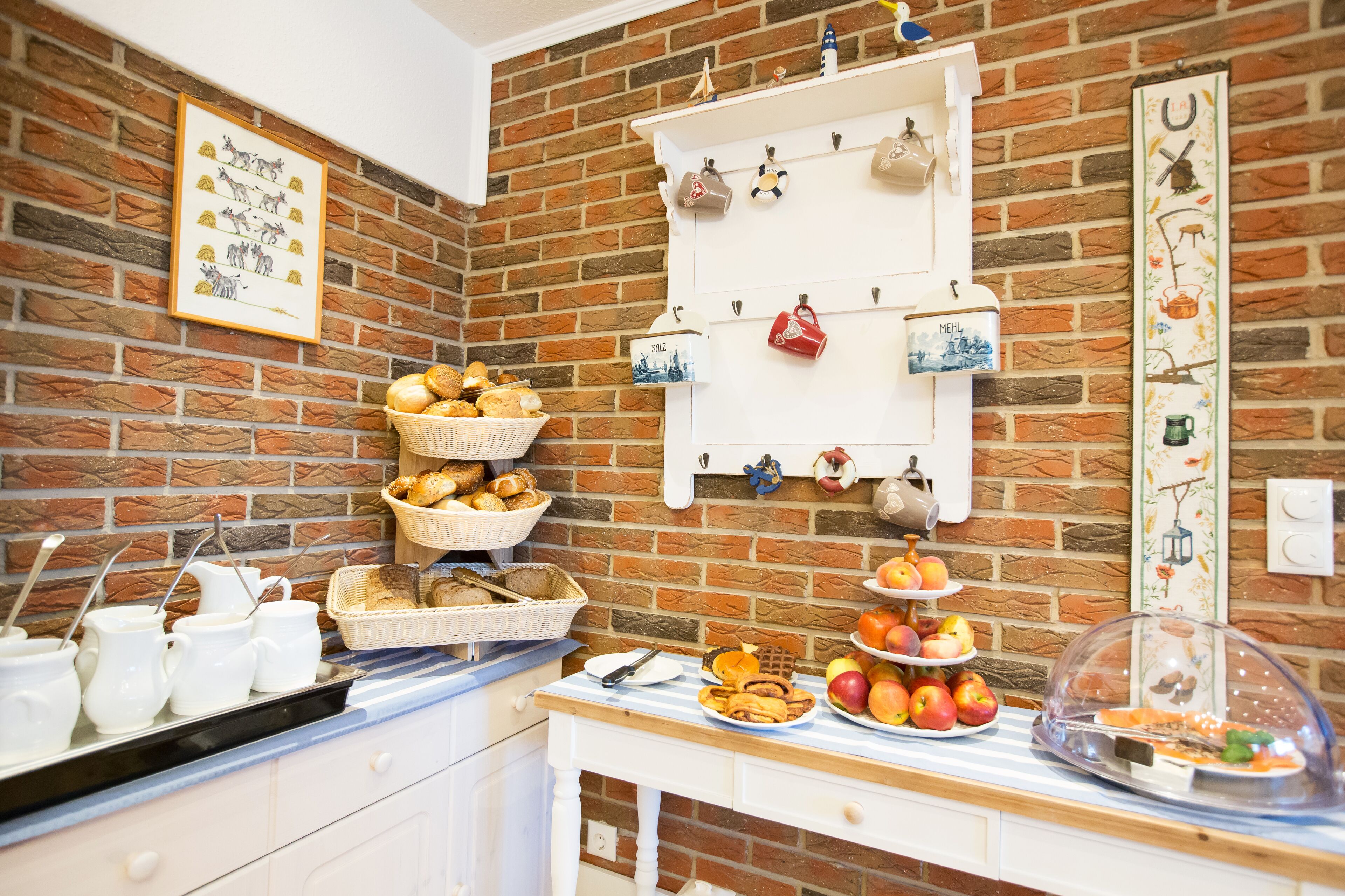 A breakfast buffet with bread, pastries, and fruit.