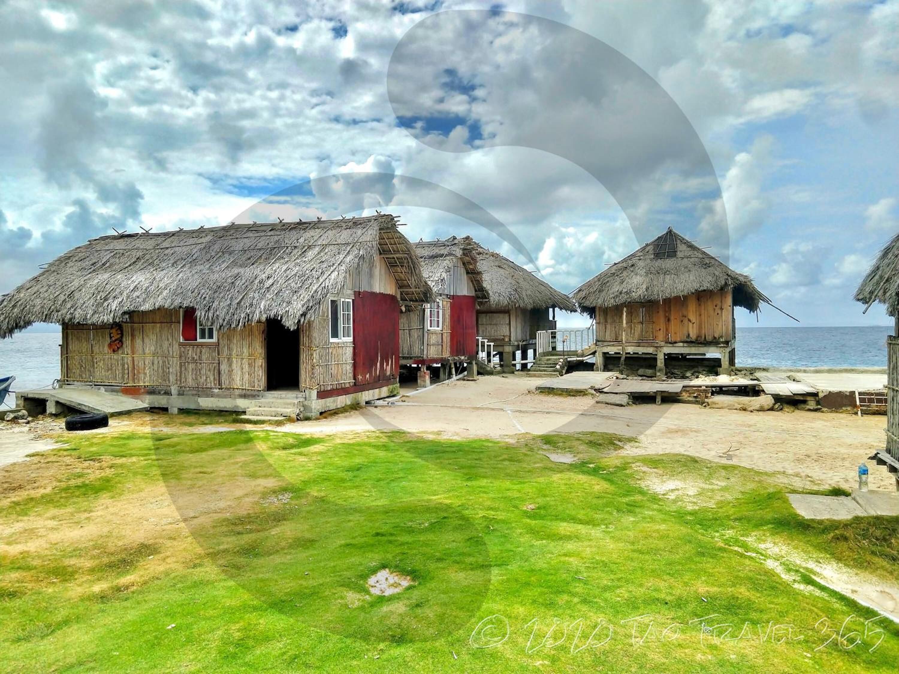 En kystlandsby med stråtækte huse og frit vue ud over havet.