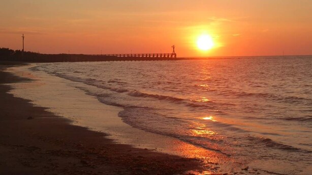A sunset over a beach with waves, a pier in the distance, and a clear sky. - Apartment F2, 4 pers, ideally located classified 2*, wifi  (Courseulles-sur-Mer)