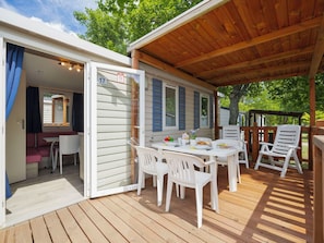 A covered outdoor area with a table and chairs, a covered seating area, and a view of the surrounding greenery. - Cosy apartment in villa for 5 people with pool, WIFI, A/C and terrace (Balatonfüred)