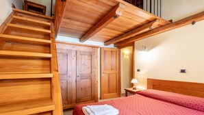A wooden staircase leading to a bedroom with a bed, a nightstand, and a wardrobe. - Beautiful apartment for 4 guests with pool, WIFI, TV and terrace (Calchesio)