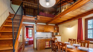A wooden interior with a staircase, a kitchen, and a dining area. - Beautiful apartment for 4 guests with pool, WIFI, TV and terrace (Calchesio)