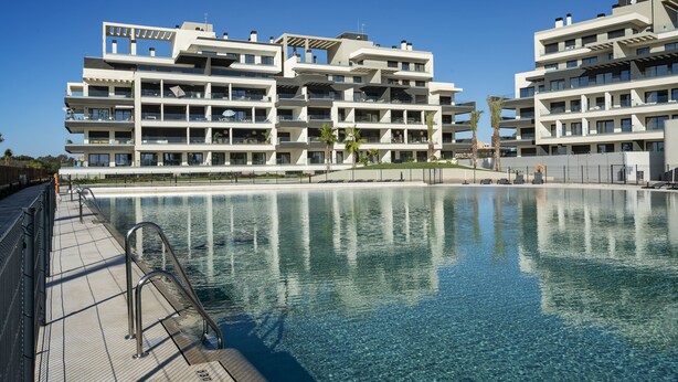 A modern hotel with a pool, multiple balconies, and a clear blue sky. - Ocean Homes Suite 2003 (Punta del Moral)