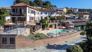 A residential area with a swimming pool, multiple houses, and a staircase leading to a balcony. - Cosy apartment for 3 guests with WIFI, pool, A/C, TV, patio and pets allowed (Cossombrato)