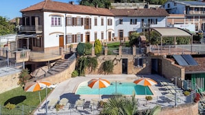 Ein Wohngebäude mit Schwimmbad, Außenbereich zum Sitzen und einer überdachten Terrasse.