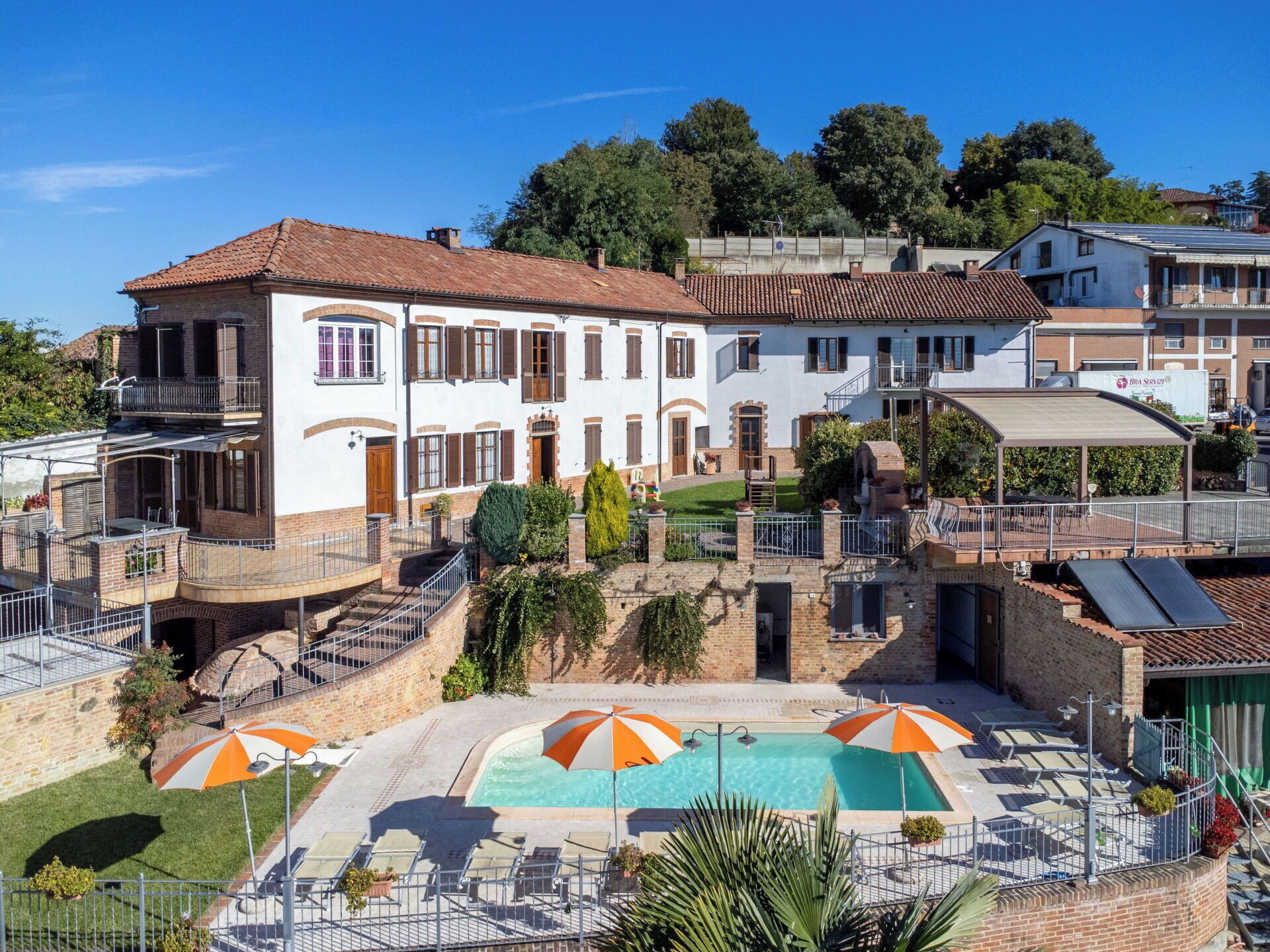 Un immeuble résidentiel doté d’une piscine, d’un espace extérieur aménagé et d’un patio couvert.