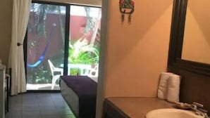 A hotel room with a large window, a bed, a bathroom with a sink, and a small balcony. - summerplace inn      (San Miguel II)