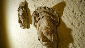 Un muro strutturato con due elementi scultorei, uno più grande e uno più piccolo, entrambi realizzati con lo stesso materiale.